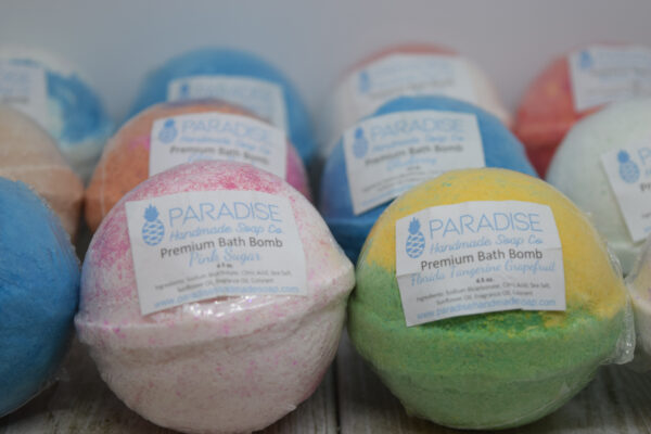Fizzy Bath Bombs by Paradise Handmade Soap. 3 rows of colorful bath bombs with labels.